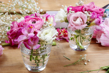Florist workplace: incomplete tiny bouquets in glass vases. Step