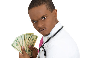 Greedy doctor. Portrait health care professional holding dollars