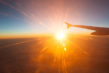 Fototapeta na wymiar View from the plane on a beautiful orange sunset