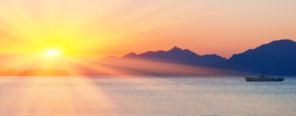 Sunset over sea and mountains
