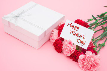 card of happy mother's day and present box and carnations