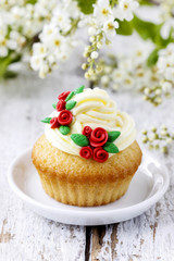 Beautiful rose cupcakes and bird cherries in the background