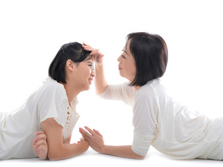 Mother and teenager daughter lying down having a fun