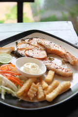 grilled salmon steak with french fries and toast.
