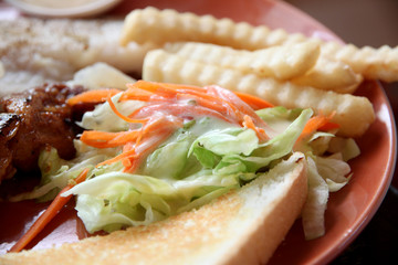 vegetable salad with french fries and toast on dish.