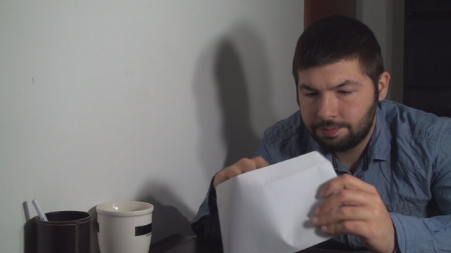 Business Man Opening An Envelope And Receiving Bad News