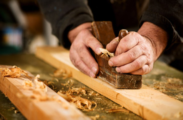 Skilled carpenter using a handheld plane