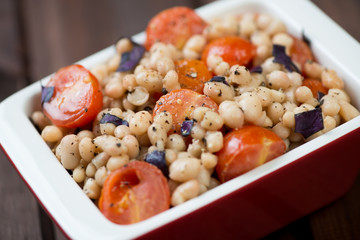 Glass bowl with roasted tomatoes and white beans, close-up