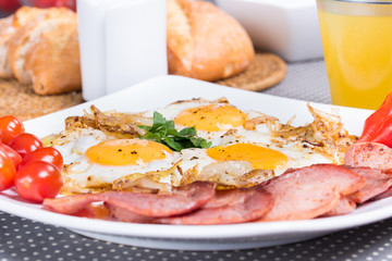Breakfast with fried eggs beacon onion and fresh tomatoes