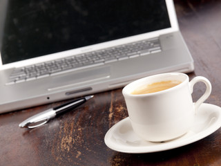 Modern laptop with a cup of coffee next to it