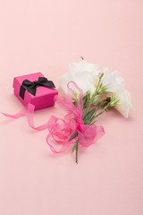 gift and flowers on pink