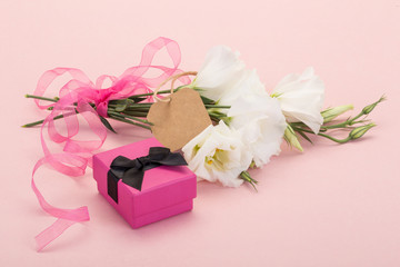 Obraz na płótnie Canvas gift and flowers on pink