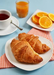 Croissants, tea and orange for breakfast