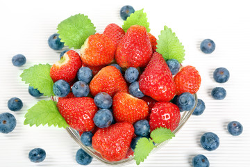Fruit salad with strawberries and blueberries in glass bowl