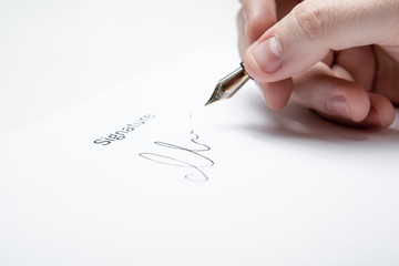 pen in the man's hand and signature