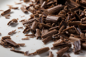 Dark chocolate shavings on a white background