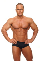 Fototapeta premium Handsome muscular man poses on white background