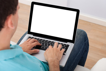 Fototapeta na wymiar Man Using Laptop At Home