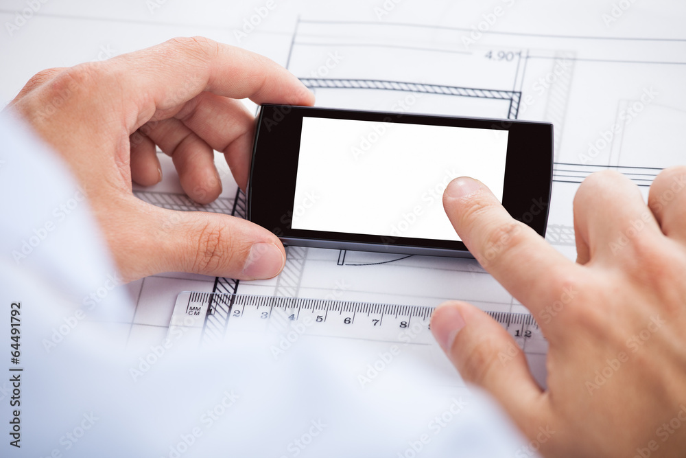 Poster architect touching smartphone's screen over blueprint