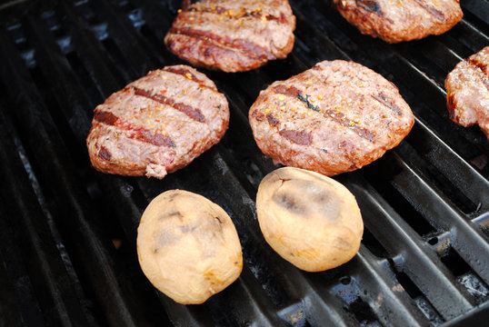 Two Whole Potatoes and Bugers on a Summer Grill