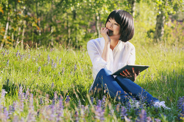 Happy asian girl using tablet outdoor