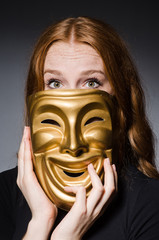 Redhead woman iwith mask in hypocrisy consept against grey backg
