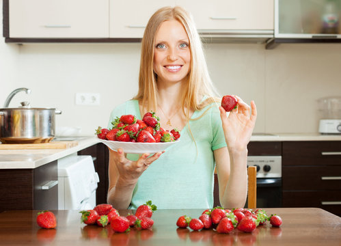 housewife with strawberries at  kitchen