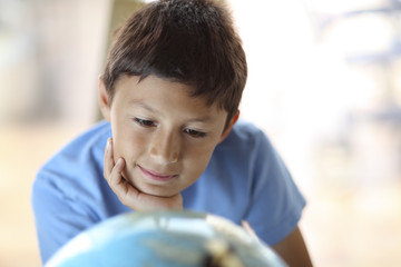 Young boy looking at a globe