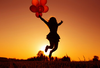 girl with balloons jumping outdoor