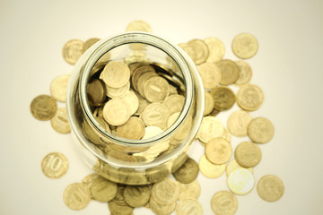 Coins spilling from a glass jar, close-up