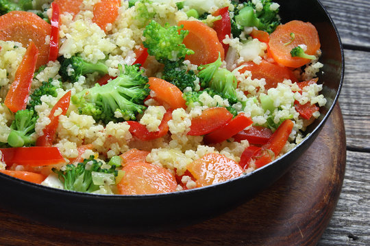 Millet fried with carrots, broccoli, paprika and onion