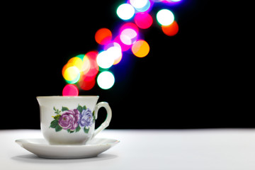 Porcelain tea cup with colorful bokeh-style vapor