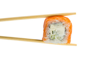 Isolated sushi roll in chopsticks. Macro.