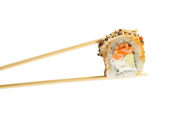 Isolated sushi roll in chopsticks. Macro.