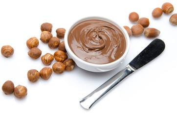 A cup of chocolate hazelnut spread with hazelnuts