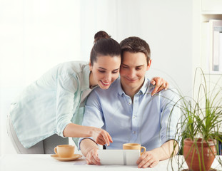 Portrait of happy couple shopping online using digital tablet