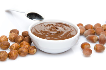 A cup of chocolate hazelnut spread with hazelnuts