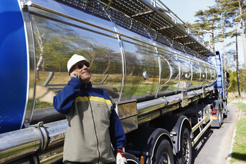 fuel truck and worker standing inside oil refinery, refuelling