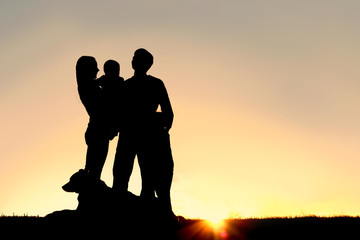 Fototapeta na wymiar Happy Young Family and Dog Silhouette at Sunset