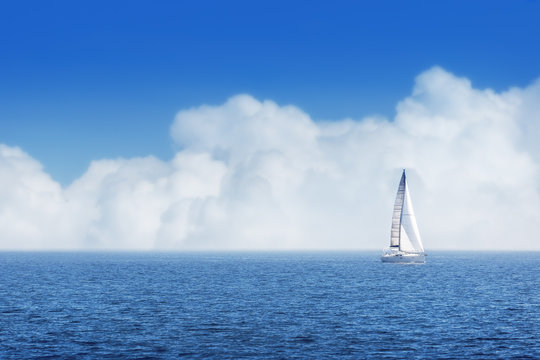 Sailing ship yachts with white sails and cloudy sky