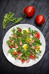 Salad with rucola, tomato, eggs and ham
