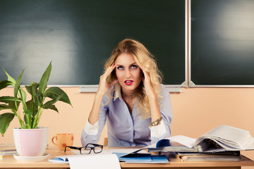 Tired teacher checking the tests.