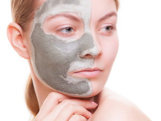 Skin care. Woman applying clay mask on face. Spa.