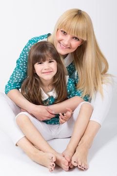 Mother and daughter with long hair with bangs smiling