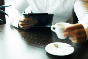 Man with tablet computer and coffee reading news at motning