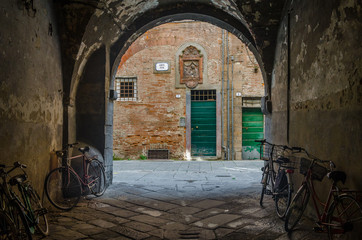 Fototapeta na wymiar Lucca (Włochy): rowery pod gankiem i kolorowe drzwi