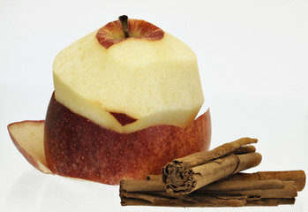 Apfel halb geschält mit Zimtstangen