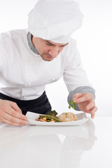 Chef decorating prepared food on plate