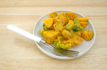 Serving of broccoli and potatoes in cheese sauce