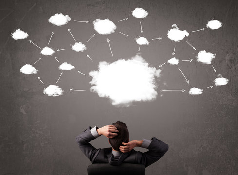 Businessman sitting with cloud technology above his head